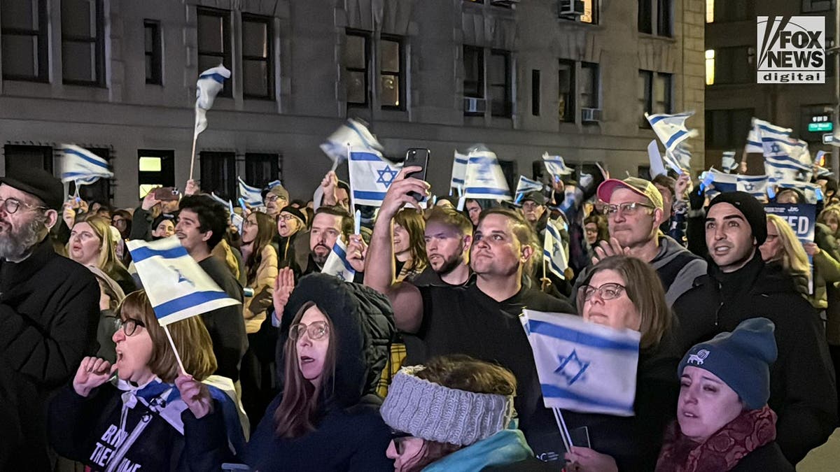 People wave Israeli flags in the street in New York