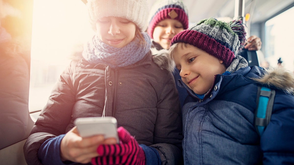 mother and sons during winter on the bus