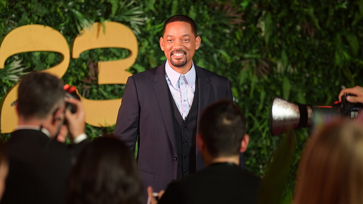 Will Smith posing in front of photographers